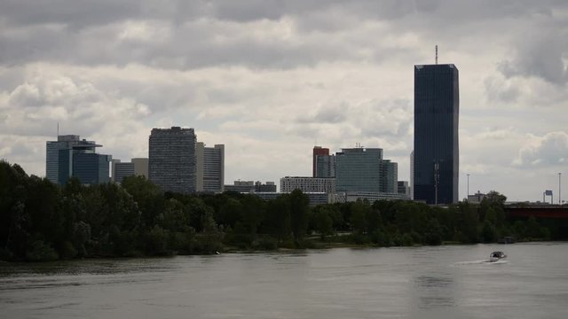 Skyline at the Danube in Vienna, Austria with a boat passing by, in 4K resolution