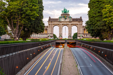 Fototapeta premium Dramatic view of the Triumphal Arch and Belliard Tunnel in Park Cinquantenaire in Brussels during sunset