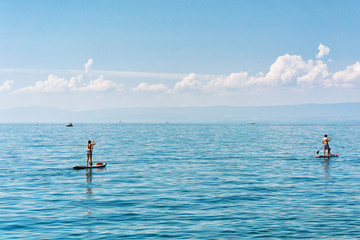 Fototapeta na wymiar People with Standup paddle surfing board Geneva Lake Swiss Riviera