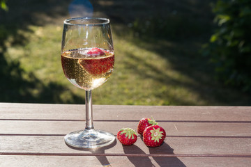 Backlit glass with sparkling wine and strawberries