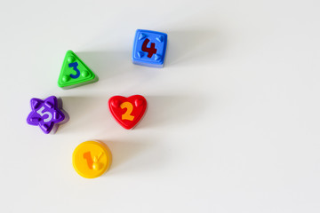Colorful plastic shapes with numbers on a white background