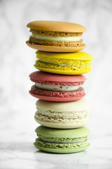 Delicious French colorful macaroons lie on a marble table
