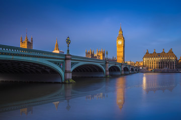 Fototapeta na wymiar London, England - The iconic Westminster bridge and Big Ben reflecting on River Thames at sunrise with clear blue sky