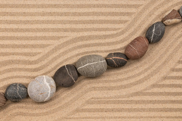 Fototapeta na wymiar Still life. Striped stones lying on striped sand.