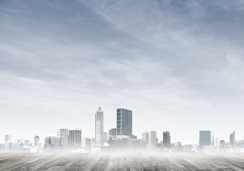 Obraz premium Modern urban buildings skyscrapers blue cloudy sky background and wooden textured platform