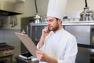 chef cook calling on smartphone at restaurant kitchen