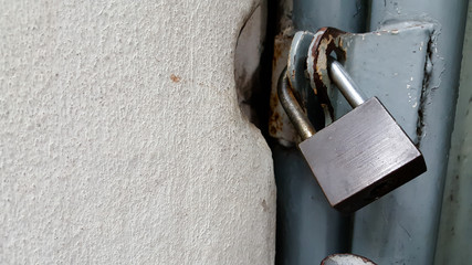 Locked rusty padlock on old wooden door