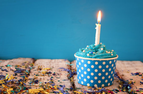 Birthday concept with cupcake and candle on wooden table