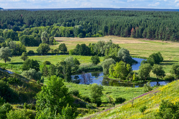 Fototapeta na wymiar Summertime landscape - river valley of the Siverskyi (Seversky) Donets, the winding river over the meadows between hills and forests, border region of Ukraine near to Russia