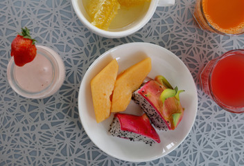Healthy breakfast, nutrition concept: yogurt , fruits, nuts, fresh carrot juice, coffee. Balanced diet
