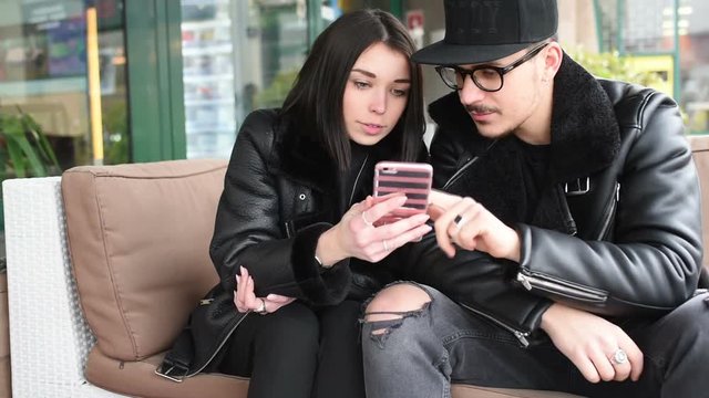 Young beautiful couple outdoor in the city using smart phone - technology, love, social network concept
