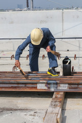 Worker scrub and paint the rail at welding point for protect rust occur. sky train. Bangkok Thailand
