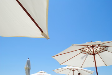 Beach umbrellas/ Beach umbrellas against the clear blue sky - 165924177