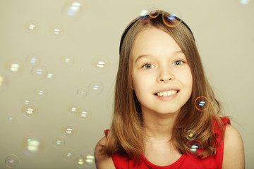 Obraz na płótnie Canvas little girl blowing soap bubbles