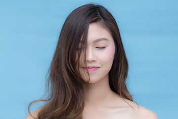 Asian beauty women smile and close her eyes on blue background