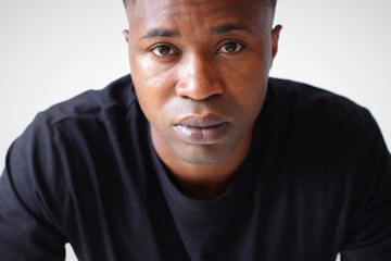 Obraz premium Schwarzer junger Mann in legeren schwarzen T-Shirt