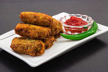 Spicy golden fried crisp cutlets served tomato sauce or ketchup on white plate, prepare for iftar Ramadan. Selective focus
