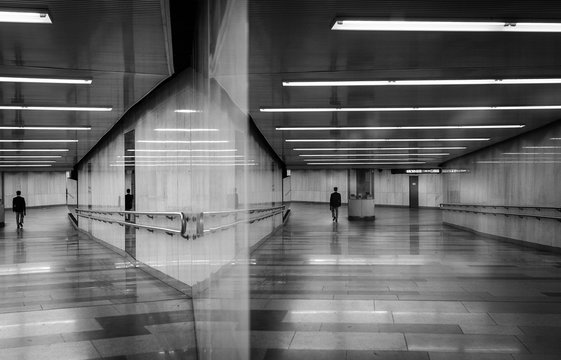 black and white art photography monochrome in noir style, a man walking the underground passage