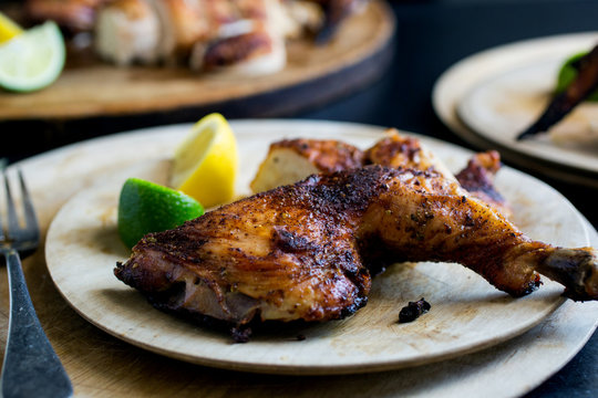 Roasted spatchcocked chicken on wooden plate