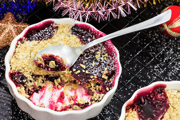 Homemade delicious crumble with berries in portioned individual ramekins. Healthy breakfast. Christmas concept