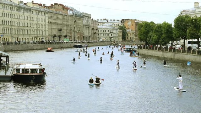 Crowd Surfing Down the River. Surfer Costume Celebration Event. Large Group of Costume Surfers. Saint Peterburg