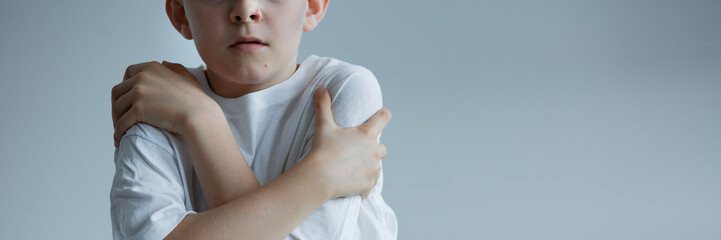 Boy embracing himself