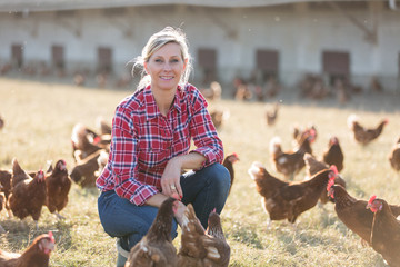 female farmer looking for eggs