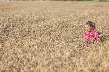 Naklejka na ściany i meble female farmer controlling cereal field