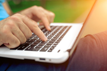 Fototapeta na wymiar Close-up shot of handsome man's hands touching laptop computer's screen.