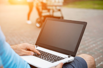 Close-up shot of handsome man's hands touching laptop computer's screen.