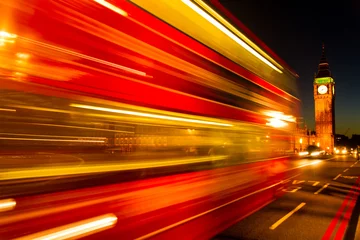 Fotobehang London red bus in movement over the Westminster Bridge with the Palace of Westminster and Big Ben on the Background at Night © fewerton