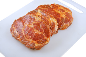 Fototapeta premium Meat, Pork neck in marinade and on a chopping boardon, on a white background
