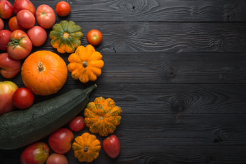 Composition of pumpkin squash and tomato on a wooden background
