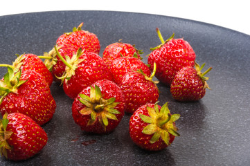 fresh ripe strawberries on black ceramic plate
