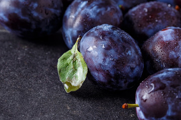 Fresh plums on dark background.