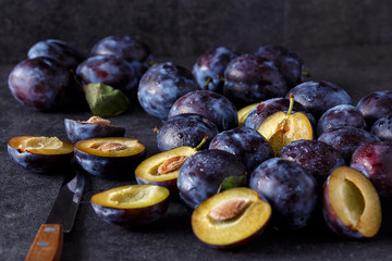 Blue fresh juicy plums on dark table.