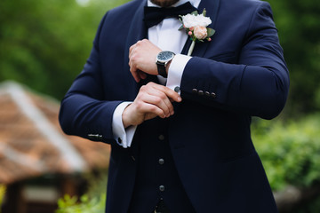 Businessman checking time on his wristwatch. men's hand with a watch.