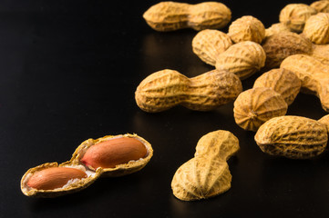 Peanuts in shell on dark background, close up