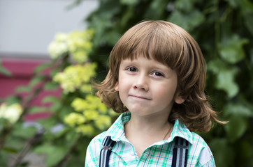 Portrait of a boy on a background of green nature 