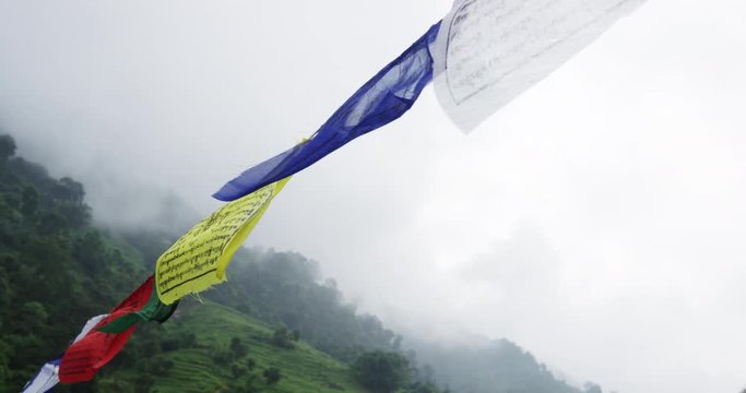 Close up, flags hang in mountain landscape