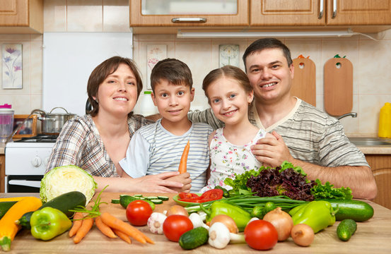 family portrait in kitchen interior at home, fresh fruits and vegetables, healthy food concept, woman, man and children cooking and having fun