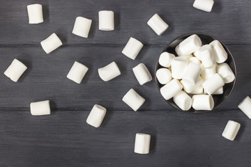 White marshmallow in a cup on a black wooden background. - 165950929