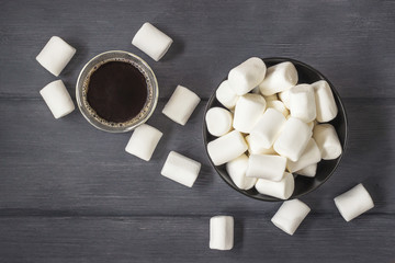 Coffee  with marshmallows on black wood table with copy space