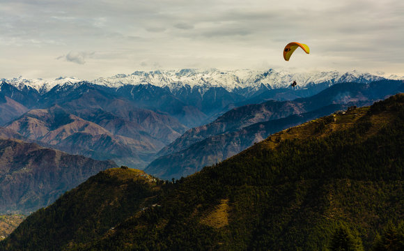 Para Gliding adventure at beautiful valley of Khajjiar, Himachal Pradesh, India. Himalayan Mountains in the background.
