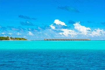 Wooden villas over water on horizont of the Indian Ocean, Maldives