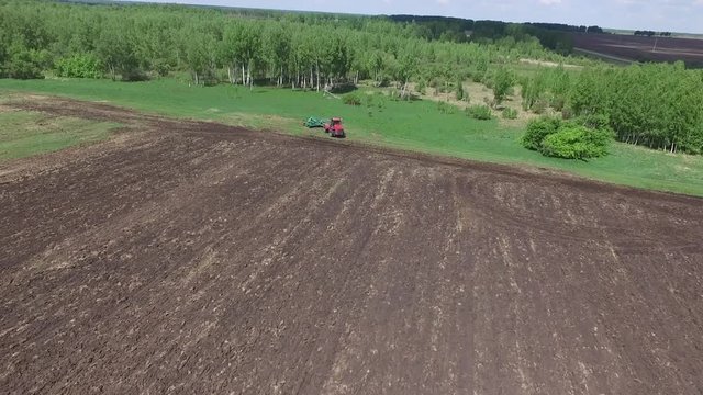 Agriculture machine spread fertilizer on cultivated field soil in summer. Planting crops