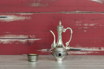 Oriental silver teapot and a cup of tea