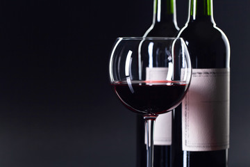 Bottles and glass of red wine .