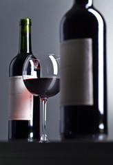 Bottles and glass of red wine .