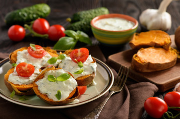 Baked sweet potatoes served with tzatziki dip.